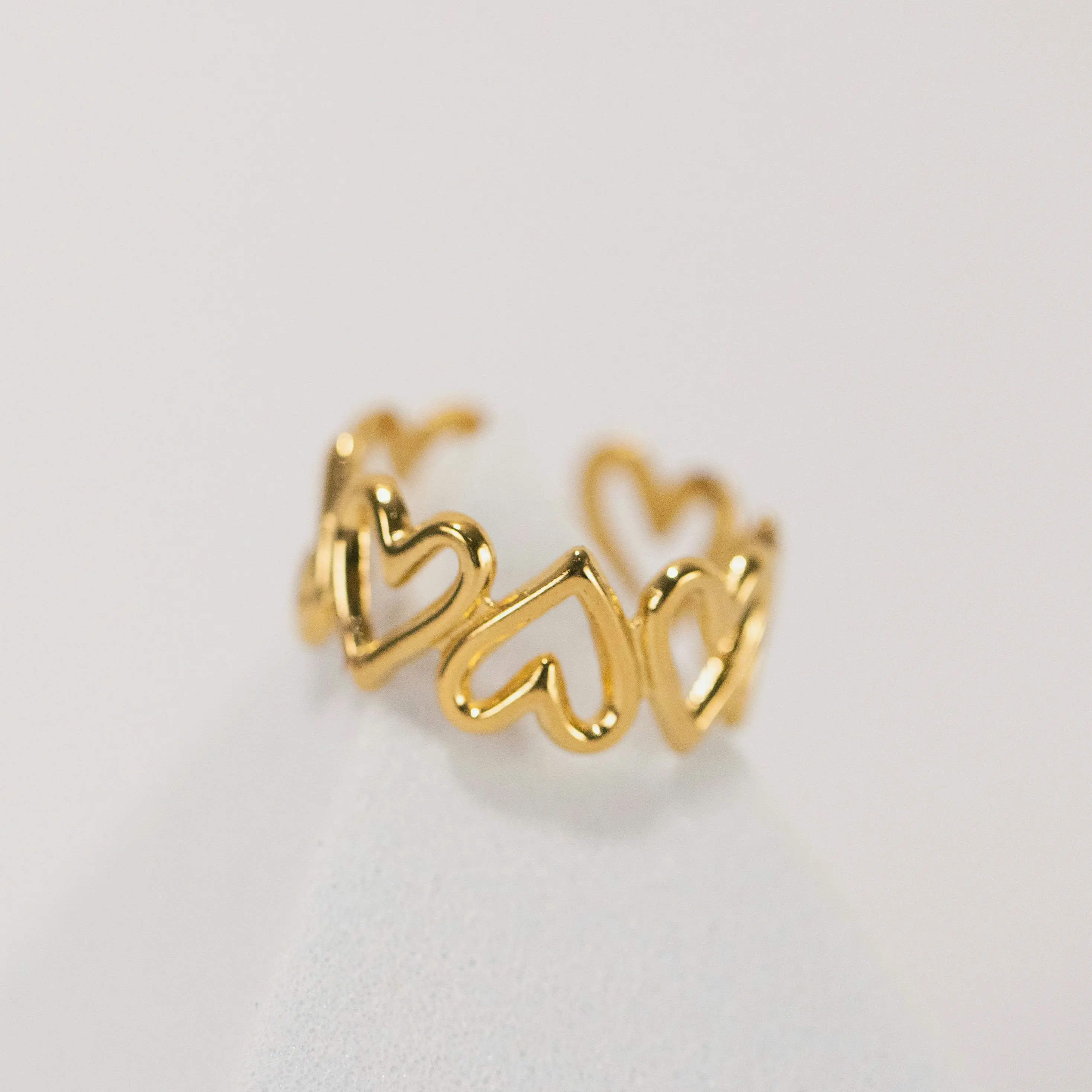 Anillo de oro con aro de varios corazones unidos.