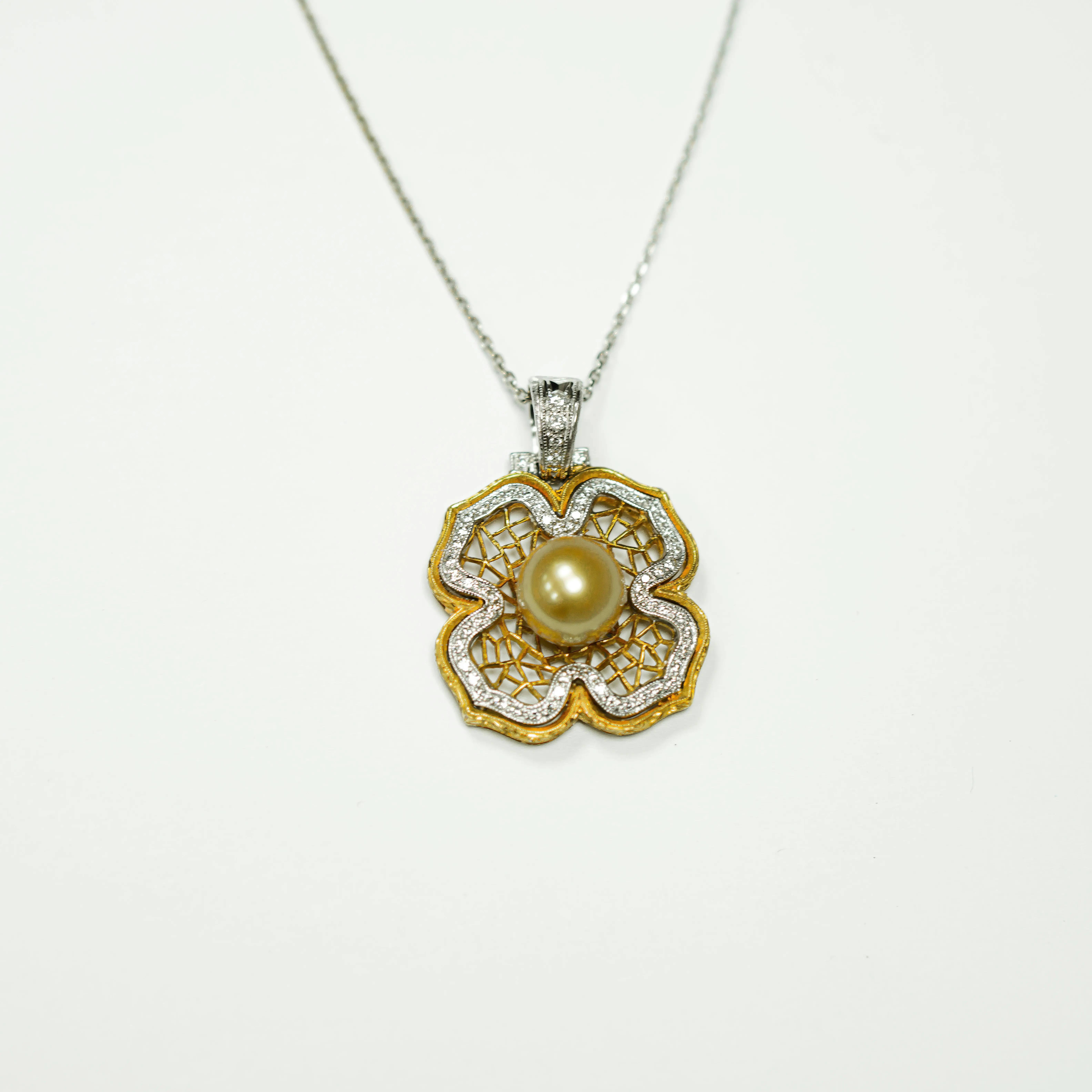 Colgante flor de oro con circonitas y perla.