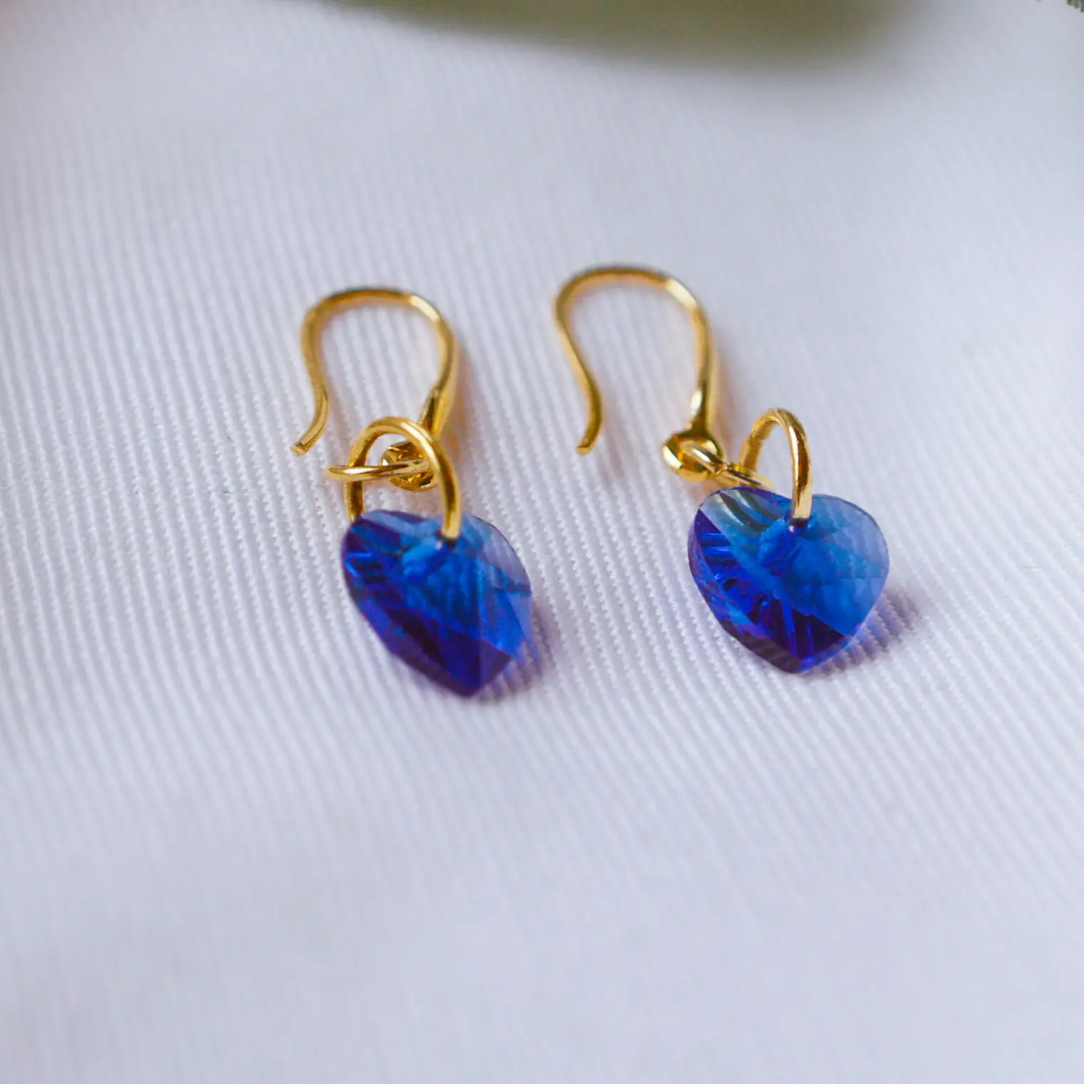 Pendientes de oro con cristales corazón azules.